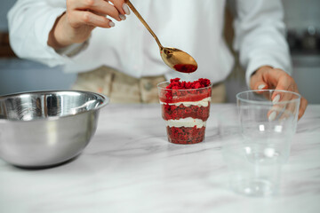 Process of creating red velvet trifle. Confectioner at work