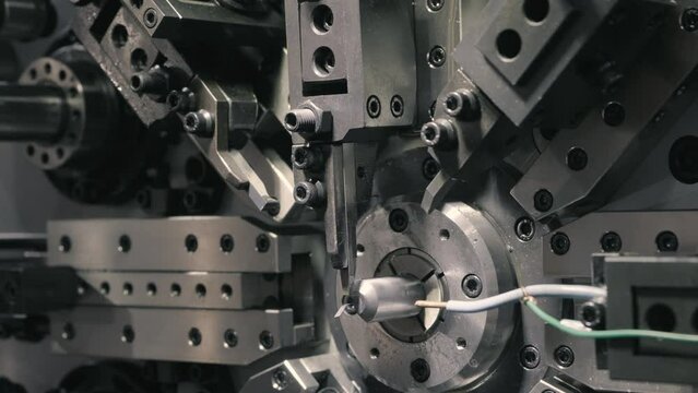 Close up scene the spring coiling machine operation. The mechanical parts manufacturing concept.