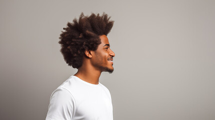 Modern young man showcasing his curly Afro hair against a neutral background.