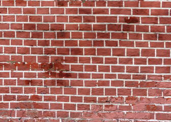 The wall is made of old red brick.