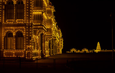 Side view of illuminated Mysore Palace in the state of Karnataka, India, the historical royal residence of the Wadiyar dynasty
