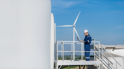 Two engineers working and holding the report at wind turbine farm Power Generator Station on...