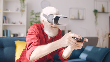 A gray-haired mature man has fun playing video games in virtual reality using a VR headset