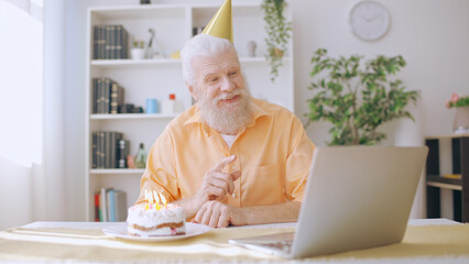 Senior man celebrates his birthday alone, yet remains connected through an online video call with his family