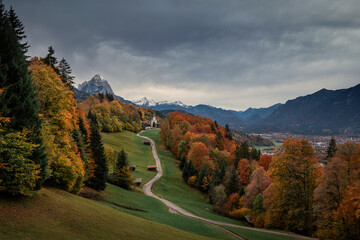Bavarian Alps with church of Wamberg in Garmisch-Partenkirchen during autumn, snow-covered...