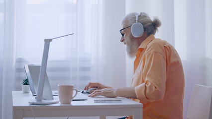 Senior man plays a video game on his laptop, upset about losing, yet committed to his retirement...