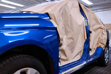 Restoration and repair of cars. A blue car in the workshop preparing the car for painting.