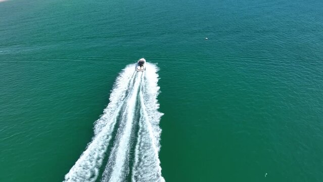 Drone view of a  Luxury boat the blue clear waters. Top view of a fast movement  white boat sailing to the blue sea. Large speed boat moving at high speed. Summer image.