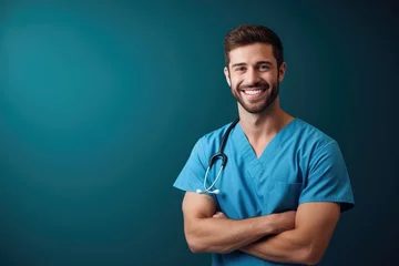 Fotobehang Portrait of a smiling happy male medical doctor or nurse standing isolate on blue background, Medical concept. © Thanaphon