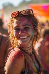 Radiant young woman covered in colorful powder at festival.