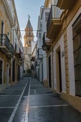 Fototapeta na wymiar Historic Street View, Iconic Bell Tower Amidst Traditional Architecture