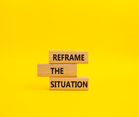 Reframe the situation symbol. Concept words Reframe the situation on wooden blocks. Beautiful yellow background. Business concept. Copy space.