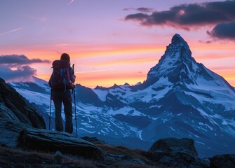 Obraz premium A woman trekker stands atop Matterhorn, surrounded by the unique beauty of the Alps, a testament to the majesty of nature and the thrill of alpine adventure