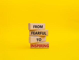 From Fearful to Inspiring symbol. Concept words From Fearful to Inspiring on wooden blocks. Beautiful yellow background. Business and From Fearful to Inspiring concept. Copy space.
