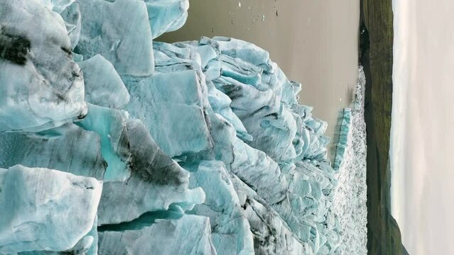 Aerial view of white glacier. Epic Drone Shot iceberg. Aerial vertical, vertical video background.