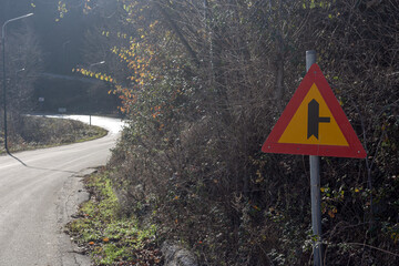 Sign "Adjacent secondary road" on a autumn day on a mountain road