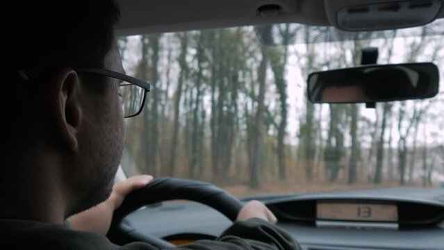 A disabled person drives a car. He is driving on the way to the meeting, a car is also driving.