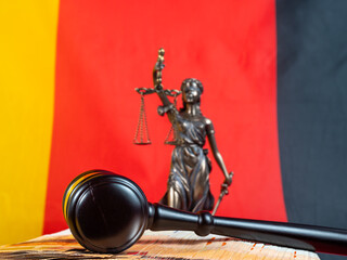 The judge's gavel lies on 50 euro bills against the background of the German flag. Law and justice...