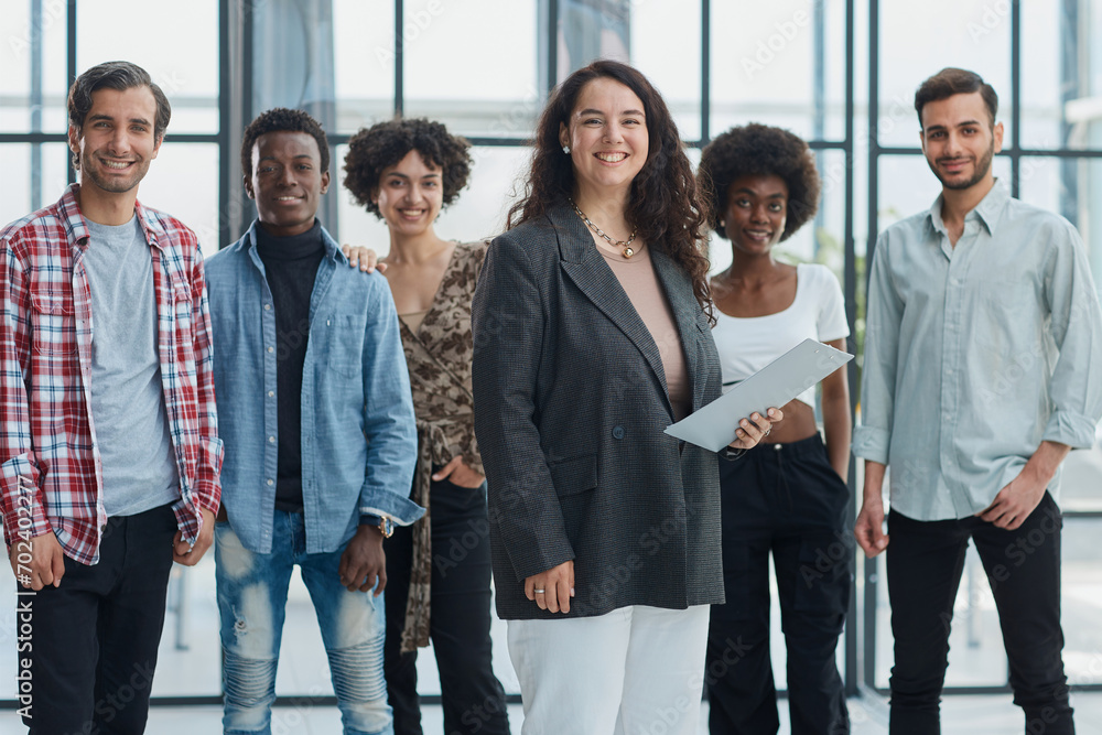 Wall mural business woman with her staff in background at office