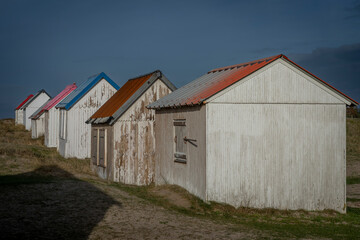 Obraz premium Gouville, France - 12 30 2023: View of colorful bathing wooden cabins of Gouville on the dunes.