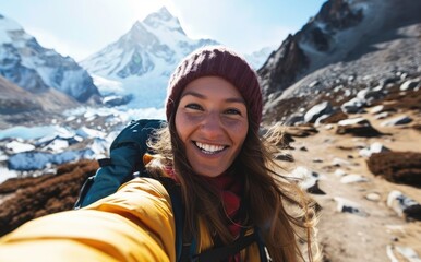 Everest Triumph: A smiling native woman with a backpack takes a selfie near the Everest summit, exuding joy and triumph in her incredible travel adventure through the Himalayas.

 - obrazy, fototapety, plakaty