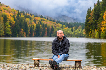 Man on the shore of a lake in the mountains