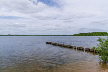 Old wooden breakwater on the shore of the lake