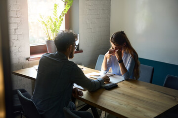 Young caucasian male boss have meeting with crying female employee in office