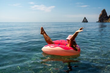 Summer vacation woman in hat floats on an inflatable donut mattress. Happy woman relaxing and enjoying family summer travel holidays travel on the sea.