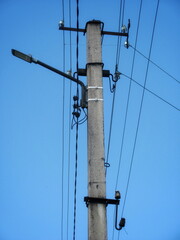 Fototapeta na wymiar Old concrete power line pole on sky background