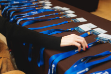 Process of checking in on a conference congress forum event, registration desk table, visitors and attendees receiving a name badge and entrance wristband bracelet and register electronic ticket