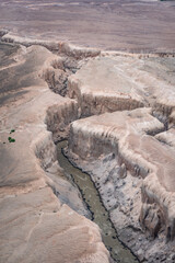 Valley of Ten Thousand Smokes in Katmai National Park and Preserve, Alaska. Valley between mountains filled with ash flow from Novarupta eruption in 1912. Deep canyon with snow bridge covered in ash.