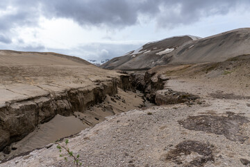 Valley of Ten Thousand Smokes in Katmai National Park and Preserve, Alaska. Valley between mountains filled with ash flow from Novarupta eruption in 1912. Deep canyon cut by river flowing through ash.