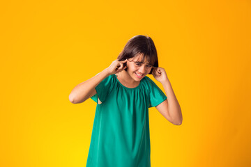 Girl ignoring stressful environment, closed ears with hands