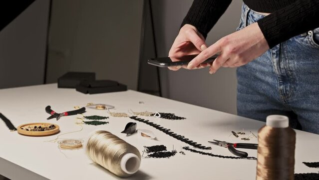 side view on Creative jewellery artist is taking photo of handmade earrings with smartphone.