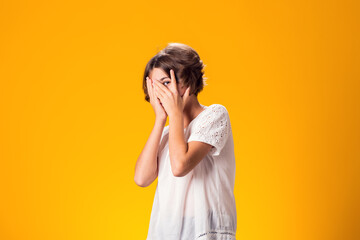 Sad kid girl over yellow background. Frustration concept