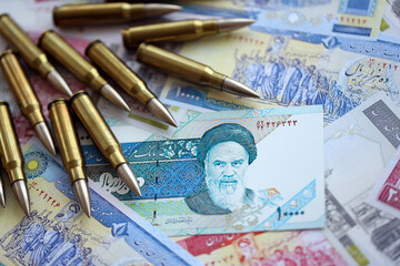 Many bullets and iranian rials money bills close up. Concept of terrorism funding or financial...