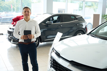 Employees of car dealership in office clothes stand by white car