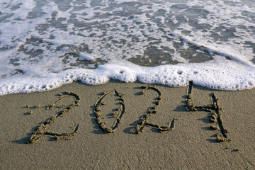 Number 2024 written on beach sand  