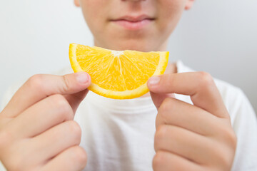 boy eating a slice of orange, close-up