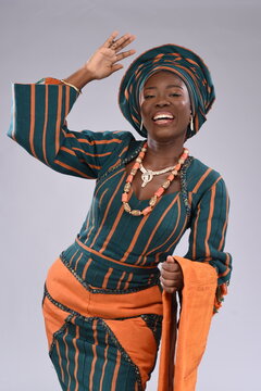 Smiling Happy Young black African Nigerian Yoruba looking gorgeous wearing native attire dancing motion 