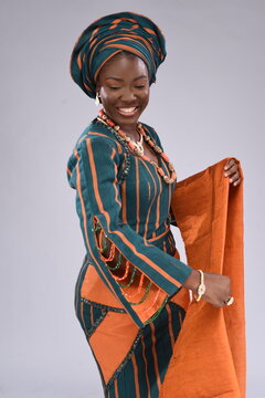 Young black African Nigerian Yoruba looking gorgeous wearing native attire dancing motion 