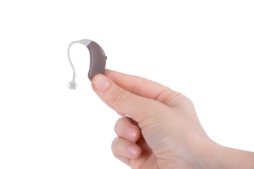 Hearing aid device in hand isolated on transparent png background with clipping paths. Deaf ear aid. Medical device.