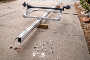 assembling a light and long aluminum kayak or canoe trailer in a driveway - obrazy, fototapety, plakaty