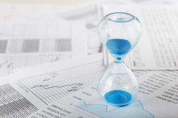 Best time for investment. Hourglass, financial charts and calculator.