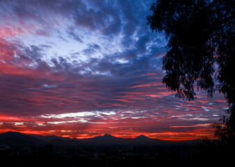 Rojo amanecer, cielo nublado, popocatepetl y 
Iztaccíhuatl
