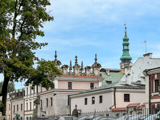 Urban buildings and in the background the bell tower and Cathedral of the Resurrection of the Lord and Saint Thomas the Apostle in Zamosc, Poland