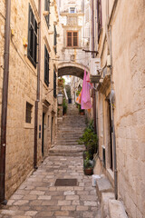 Fototapeta na wymiar The medieval city of Dubrovnik, Dalmatia, Croatia. Narrow street with a staircase and an arch.