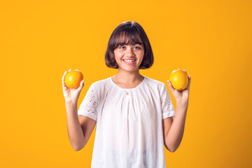 Girl holds an oranges in hands. Healthy food and children nutrition concept