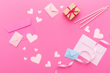 Paper hearts, love letters and gifts on a pink background. Valentine's Day. Love concept. Top view....